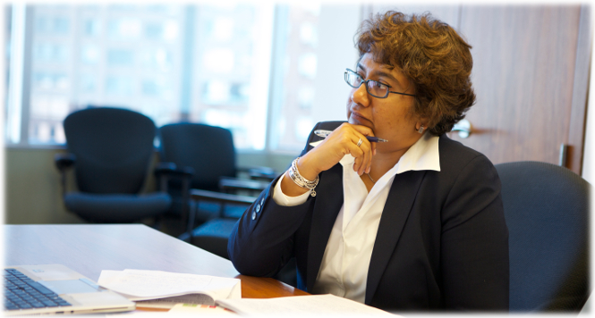 A female adjudicator listens attentively at a desk.
